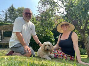 Trusted House Sitters review to find pet sitters. Read our honest review — Happy dog in garden with dog sitters 🐾